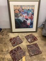 Framed art print and four relief ceramic tiles displayed on surface