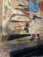 Overview showing saws, mallets, axe, hammers, bow-saw frame and blade