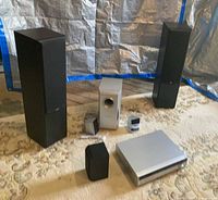 Group shot of receiver, subwoofer, tower speakers, center speaker, and satellites