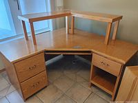 Front view of oak corner desk with two riser shelves