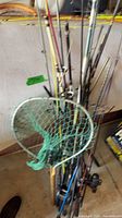 Bundle of assorted rods with green-mesh landing net front view