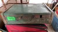 Top and front view of closed green Coleman suitcase stove