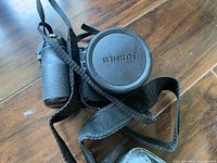 Camera front with lens cap and strap