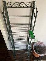 Front view of full etagere showing scrollwork and four wire shelves