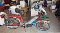 Left side view of complete Jawa moped showing frame, engine, wheels, fenders, luggage rack