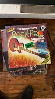Stack topped by Impact Greatest Hits of Rock and Roll LP