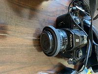 Camera body with attached lens and strap