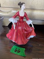 Full view of figurine front showing red floral dress and pose