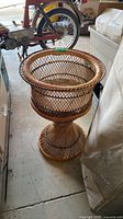 Full view of rattan pedestal planter in storage area