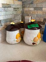All three ceramic mushroom canisters with lids shown on counter