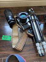 Camera body, attached lens, telephoto lens, tripod, strap visible