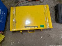 closed yellow metal case with tape residue and scuffs