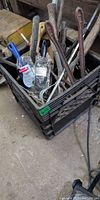 Crate with assorted tools including pry bars, paint brush in package, mixing paddle