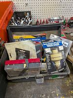 Open plastic case with packaged punch & chisel set, drill pump, light control, organizer box and other small tools visible