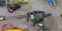 Top view of Craftsman chainsaw on shop floor showing full bar, housing, and attached tag