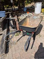 Full view of wheelbarrow showing tray, handles, tire and overall wear