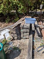 Full view of stacked weathered boards outdoors