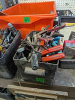 Bin of assorted hand tools on workbench