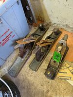 three metal hand planes on floor showing overall condition