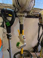 Full view of Ryobi trimmer showing engine housing, shaft and auxiliary pole