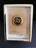 Pin in display case showing CBC logo and Jolyn 10KT marking