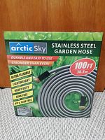 Front of Arctic Sky stainless steel garden hose box showing product features and 100 ft length