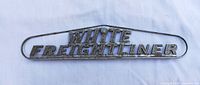 Front view of cast metal WHITE FREIGHTLINER emblem