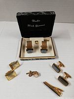 Full lot showing box with Alaska Black Diamond cufflinks, gold/black cufflinks and tie bar, engraved cufflinks, tie pins