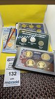 Overview of coin sets showing 1998 folders, 2001 quarters set, presidential dollars
