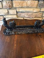 Full view of cast iron boot scraper showing both rooster figures and ornate base