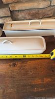 Top view of both lidded loaf pans next to tape measure indicating length