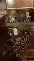 Tin open showing mixed keys, rings, tags