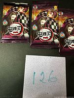 Three sealed Demon Slayer trading card packs displayed side by side