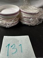 Two stacks of white Royal Doulton ramekins with pink-mauve rim bands, wrapped in original plastic