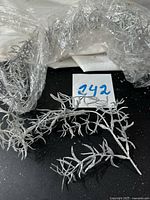 bag with several silver glitter branches on black surface