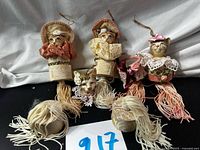 Four cat tassel ornaments, lace basket accessory and two loose tassels grouped on black surface
