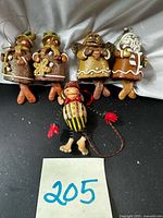 Group view of four gingerbread ornaments and one jester ornament