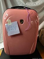 Front view showing pink hard-shell body with logo