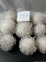 Front view of nine white curly-textured ornaments grouped together