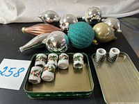 Group of glass ornaments, ceramic mini candles in tin and on lid