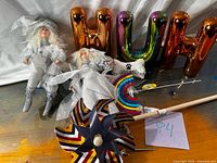 Full lot view showing dolls, pinwheel, balloons, plush bone, spinner