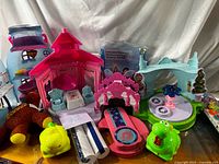 Overall lot showing playsets, plush giraffe, green dinosaur, candles, inflatable mattress