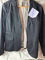 Front view of blazer on hanger, lining visible