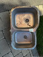 Top view of stainless steel double-bowl sink showing bowls, strainers and rim