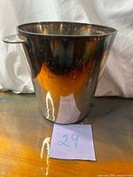 Front view of silver-plated ice bucket showing side tab handle and reflective surface