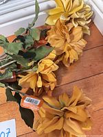 Four yellow faux dahlia stems laid out