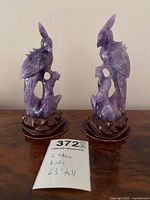 Front view of both amethyst bird figurines on wooden bases