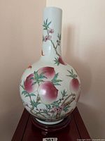 Full view of porcelain vase on stand showing shape and decoration