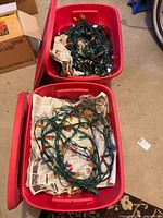 Two red totes with coiled green-wire light strings