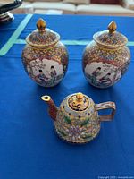 Front view of cloisonné teapot and two ginger jars with lids in place